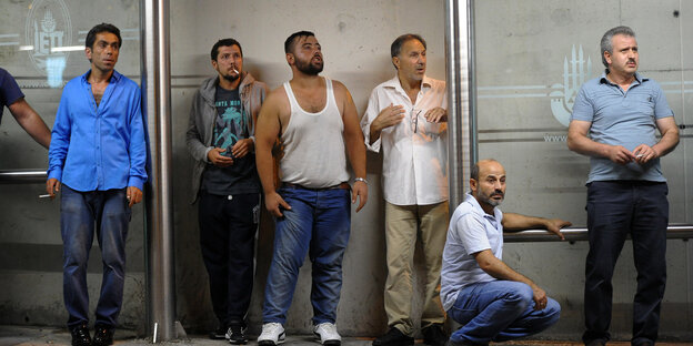 Männer in Istanbul warten an einer Bushaltestelle Männer in Istanbul warten an einer Bushaltestelle