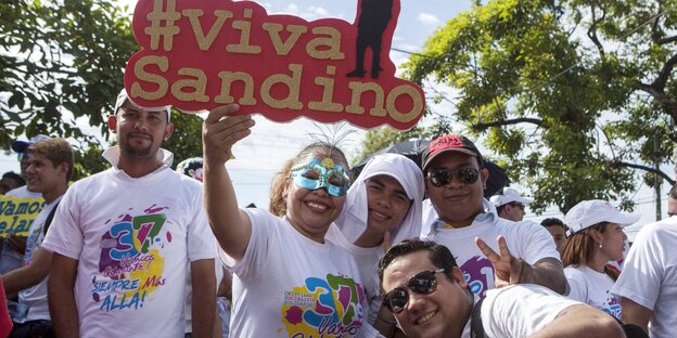Fröhliche Menschen mit bunden Tshirts und einem Schuld #Viva Sandino Fröhliche Menschen mit bunden Tshirts und einem Schuld #Viva Sandino