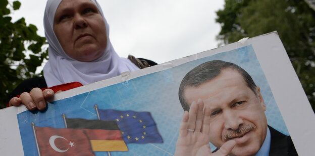 Eine Demonstrantin mit einem Plakat von Erdogan vor der Botschaft in Berlin. Eine Demonstrantin mit einem Plakat von Erdogan vor der Botschaft in Berlin.