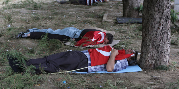 Erschöpfte Demonstranten haben sich zum Schlafen mit Nationalfahnen bedeckt