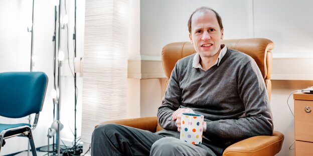 Der Wissenschaftler Nick Bostrom sitzt in einem Sessel und hält eine Tasse fest Der Wissenschaftler Nick Bostrom sitzt in einem Sessel und hält eine Tasse fest