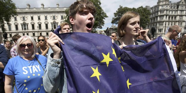 Junge Menschen auf einer Demonstration mit der EU-Fahne in den Händen Junge Menschen auf einer Demonstration mit der EU-Fahne in den Händen