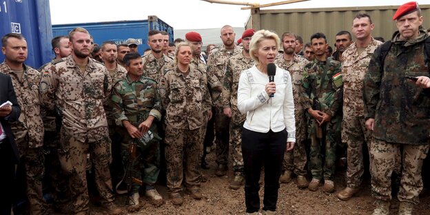 Ursula von der Leyen steht zwischen Bundeswehr-Soldaten