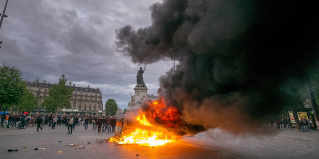Ein brennendes Auto sorgt für dunkle Rauchschwaden auf dem Place de la Republique Ein brennendes Auto sorgt für dunkle Rauchschwaden auf dem Place de la Republique