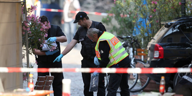 Polizisten hinter einem Absperrband Polizisten hinter einem Absperrband