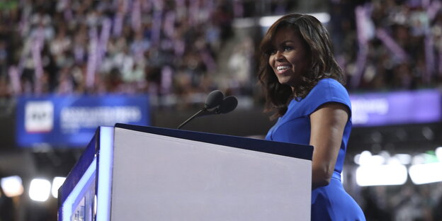 Eine Frau vor einem Pult. Es ist Michelle Obama Eine Frau vor einem Pult. Es ist Michelle Obama