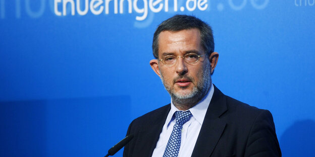 Der Verfassungsschutz-Beamte Stephan J. Kramer steht vor einer blauen Wand, auf der thueringen.de steht Der Verfassungsschutz-Beamte Stephan J. Kramer steht vor einer blauen Wand, auf der thueringen.de steht