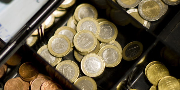 Ein-Euro-Münzen liegen in einer Kasse