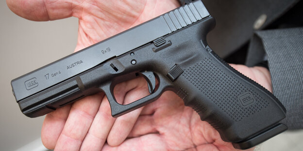Eine Pistole vom Typ „Glock 17“ in einer Hand Eine Pistole vom Typ „Glock 17“ in einer Hand