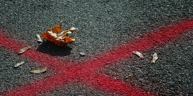 Ein rotes Kreuz ist auf eine Straße gemalt Ein rotes Kreuz ist auf eine Straße gemalt