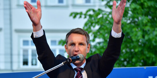 Mann hebt beide Hände, es ist der thüringische AfD-Chef Höcke