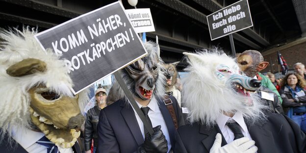 Männer mit Wolfskopf protestieren Männer mit Wolfskopf protestieren