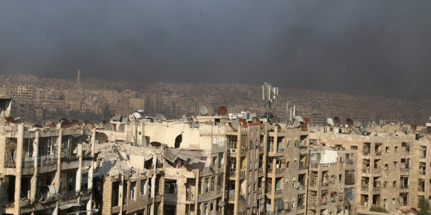 Rauch von angezündeten Reifen über den zerstörten Häusern von Aleppo