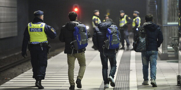 Schwedischer Polizist mit Flüchtlingen Schwedischer Polizist mit Flüchtlingen
