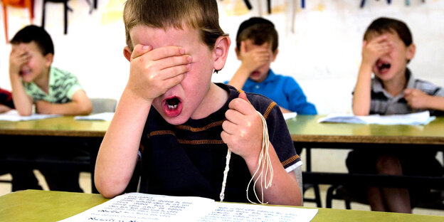 vier Jungen in einer Schule halten sich die Hand vor den Kopf vier Jungen in einer Schule halten sich die Hand vor den Kopf