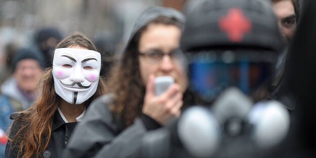 Protestler auf mit Guy Fawkes- und Atemschutzmaske Protestler auf mit Guy Fawkes- und Atemschutzmaske
