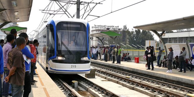 Menschen warten auf eintreffenden Zug Menschen warten auf eintreffenden Zug