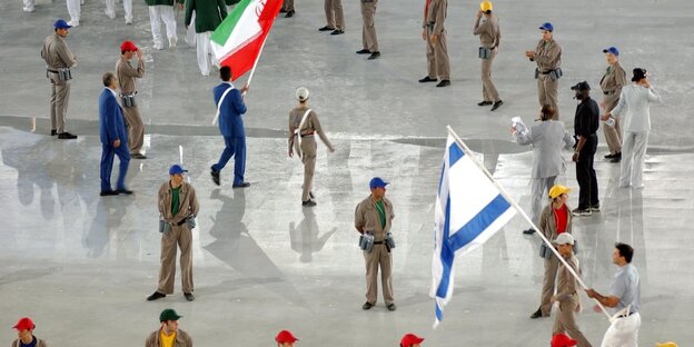 die Fahnenträger Irans und Israels umringt von Helfern die Fahnenträger Irans und Israels umringt von Helfern