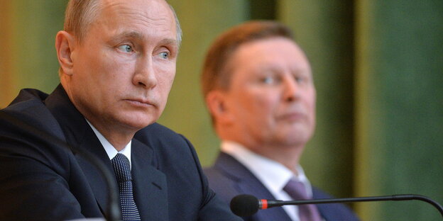 Putin und Iwanow, ein Mikro im Vordergrund Putin und Iwanow, ein Mikro im Vordergrund