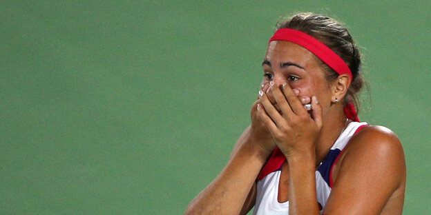 Tennisspielerin hält sich den Mund zu Tennisspielerin hält sich den Mund zu