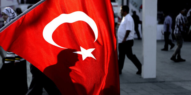 Schatten eines Mannes hinter der türkischen Flagge Schatten eines Mannes hinter der türkischen Flagge
