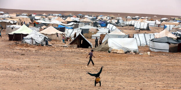 Kinder spielen in einem Flüchtlingslager in Jordanien nahe syrischen Grenze. Kinder spielen in einem Flüchtlingslager in Jordanien nahe syrischen Grenze.