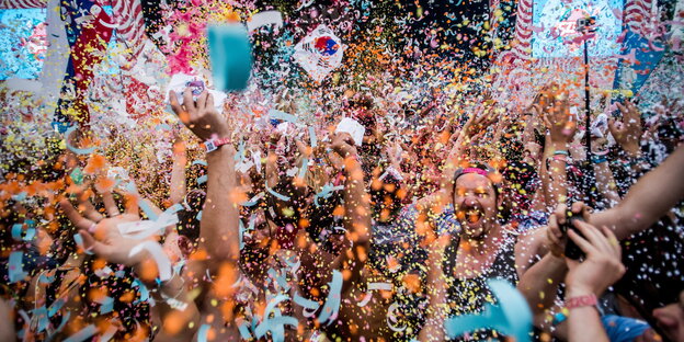 Festivalbesucher tanzen und werfen Konfetti auf dem Sziget Festivalbesucher tanzen und werfen Konfetti auf dem Sziget