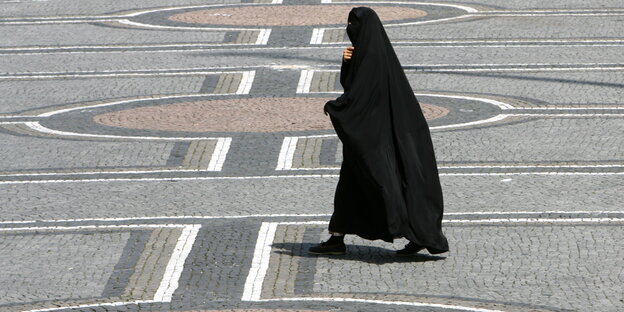 Eine Frau in einer Burka geht über den Odeonsplatz in München Eine Frau in einer Burka geht über den Odeonsplatz in München