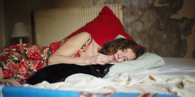 Nathalie (Isabelle Huppert) liegt auf dem Bett und streichelt eine Katze. Nathalie (Isabelle Huppert) liegt auf dem Bett und streichelt eine Katze.