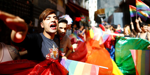 Menschen mit Regenbogenflaggen auf einer Straße
