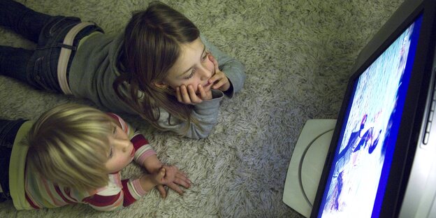 Zwei Kinder schauen Fernsehen - Vogelperspektive Zwei Kinder schauen Fernsehen - Vogelperspektive