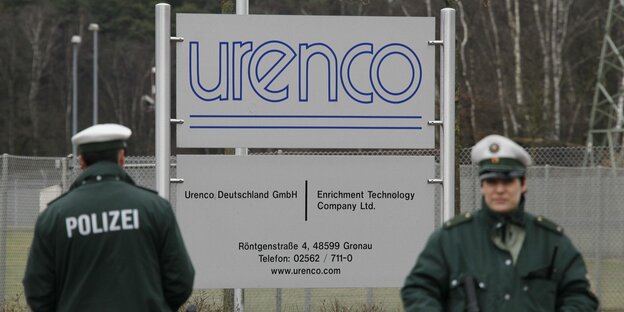 Zwei Polizisten stehen vor einem Schild mit der Aufschrift Urenco Zwei Polizisten stehen vor einem Schild mit der Aufschrift Urenco