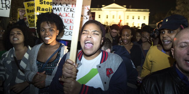 Vor dem Weißen Haus in Washington protestieren Menschen mit Schildern gegen Polizeigewalt gegen Schwarze Menschen Vor dem Weißen Haus in Washington protestieren Menschen mit Schildern gegen Polizeigewalt gegen Schwarze Menschen