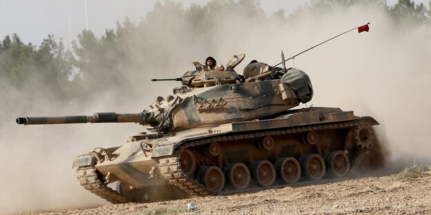 Ein Panzer fährt über staubiges Feld Ein Panzer fährt über staubiges Feld