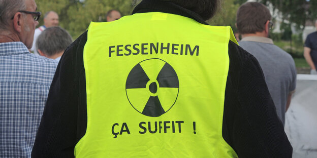 Eine neongelbe Warnweste mit einem Atomkraftzeichen von hinten Eine neongelbe Warnweste mit einem Atomkraftzeichen von hinten