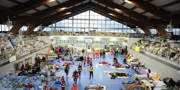 Rettungsarbeiter und Opfer des Erdbebens in einer Sporthalle