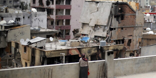Eine Frau ist von hinten zu sehen als sie auf zerstörte Häuser der Stadt Cizre blickt Eine Frau ist von hinten zu sehen als sie auf zerstörte Häuser der Stadt Cizre blickt