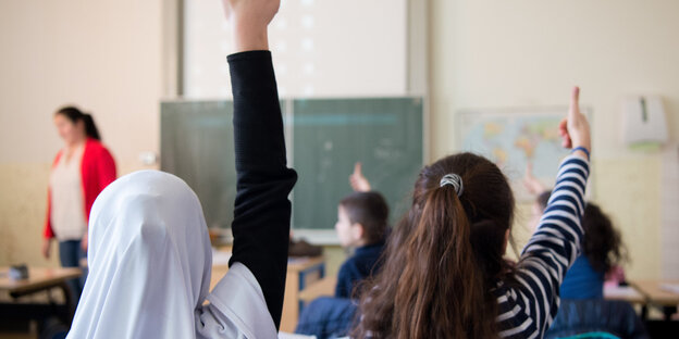 Zwei Schülerinnen melden sich im Unterricht Zwei Schülerinnen melden sich im Unterricht