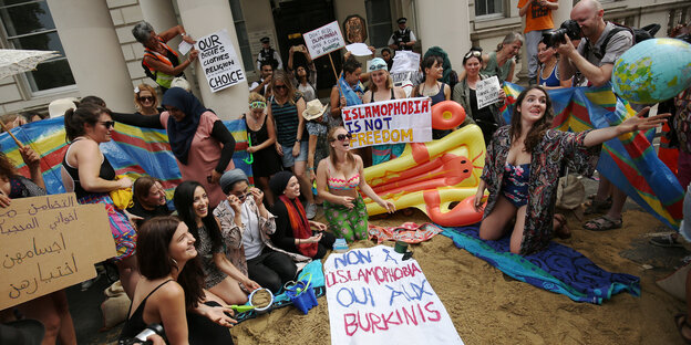 Eine Gruppe Frauen in Badeklamotten und mit Demo-Transparenten, die Stimmung ist gut Eine Gruppe Frauen in Badeklamotten und mit Demo-Transparenten, die Stimmung ist gut