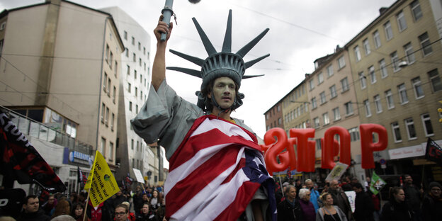 Foto einer Anti-TTIP-Demo, ein Mann verkleidet als Freiheitsstatue Foto einer Anti-TTIP-Demo, ein Mann verkleidet als Freiheitsstatue