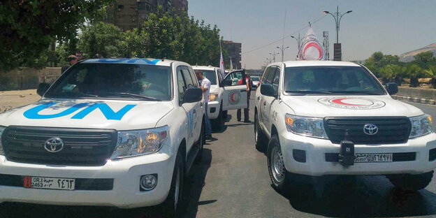 Ein Auto mit Aufschrift „UN“, daneben eines des Syrischen Roten Kreuzes Ein Auto mit Aufschrift „UN“, daneben eines des Syrischen Roten Kreuzes