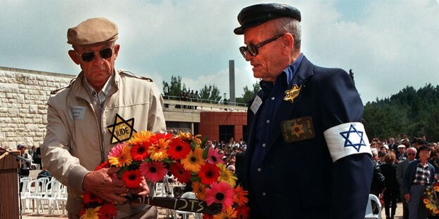 David Monk (l) und Mordechai Fuchs (r) tragen einen Trauerkranz