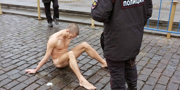 Ein nackter Mann, Pjotr Pawlenski, auf einer Straße Ein nackter Mann, Pjotr Pawlenski, auf einer Straße