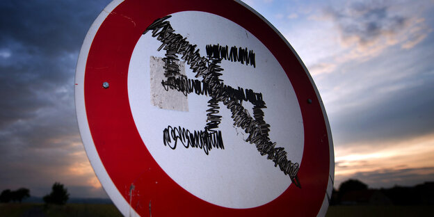 Auf ein Durchfahrtverbotenschild ist ein durgestrichenes Hakenkreuz gemalt, dahinter ein So Auf ein Durchfahrtverbotenschild ist ein durgestrichenes Hakenkreuz gemalt, dahinter ein So