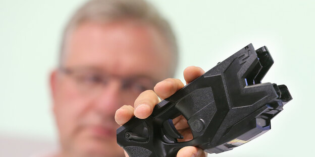 Innensenator Frank Henkel (CDU) hält einen Taser in der Hand Innensenator Frank Henkel (CDU) hält einen Taser in der Hand