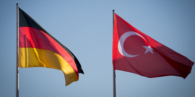 eine deutsche und eine türkische Nationalflagge wehen im Wind vor blauem Himmel eine deutsche und eine türkische Nationalflagge wehen im Wind vor blauem Himmel