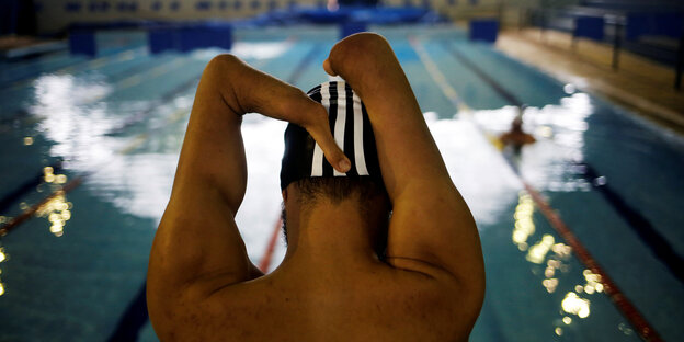 Der paralympische Schwimmen Daniel Dias am Beckenrand. Dias hat keine Unterarme Der paralympische Schwimmen Daniel Dias am Beckenrand. Dias hat keine Unterarme