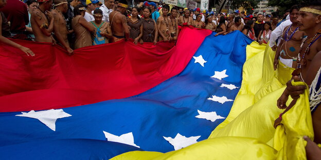 Menschen halten eine gigantische Venezuela-Flagge Menschen halten eine gigantische Venezuela-Flagge