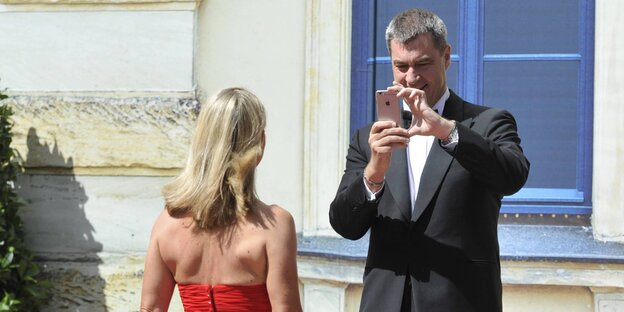 Markus Söder und Karin Baumüller-Söder machen ein Selfie mit einem IPhone Markus Söder und Karin Baumüller-Söder machen ein Selfie mit einem IPhone