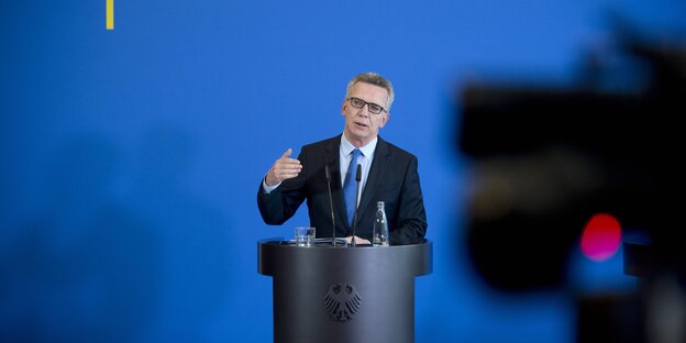Thomas de Maizière spricht hinter einem Rednerpult Thomas de Maizière spricht hinter einem Rednerpult